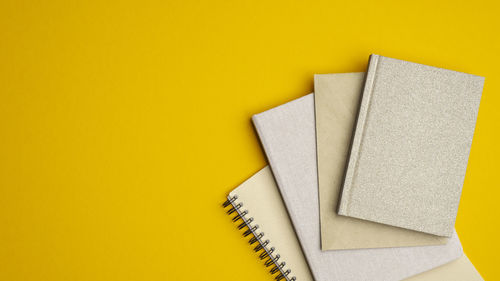 High angle view of book on paper against yellow background