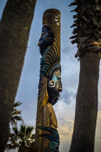 Low angle view of statue against tree trunk