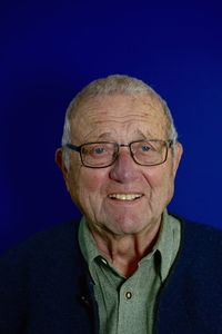 Portrait of man wearing eyeglasses against blue background