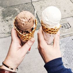 Cropped hands holding ice cream cones