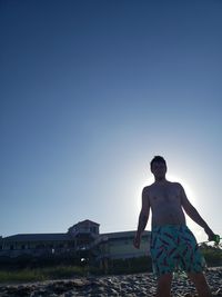 Man standing against clear blue sky