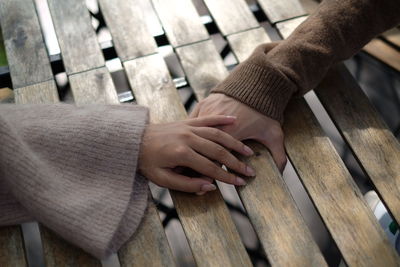 Close-up of hands touching wood