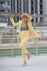 Urban style street fashion photosoot young model wearing yellow trendy suit
