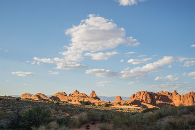 Rock formations on landscape against cloudy sky