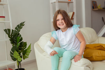 Portrait of young woman sitting on sofa at home