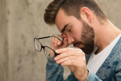 Side view of young man smoking cigarette