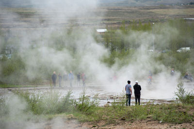 Tourists visiting and waiting for the eruption of strokkur geyser in the golden circle of iceland