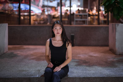 Portrait of a young woman sitting outdoors