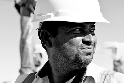 Close-up of smiling young man standing against sky