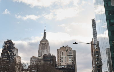 Buildings in city against cloudy sky