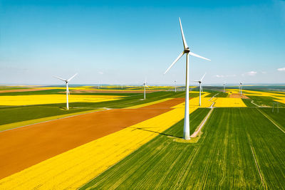 Windmills on field against sky