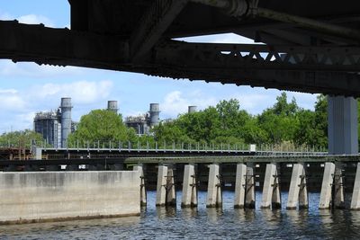 Bridge over river in city against sky