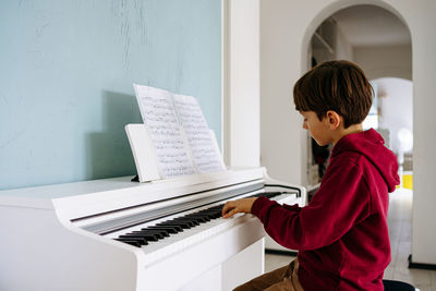 Boy playing piano at home