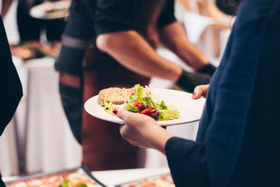 Midsection of woman having food in restaurant