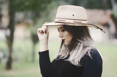 Side view of young woman wearing hat