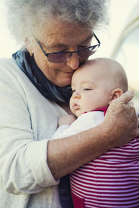 Close-up of grandmother embracing baby boy