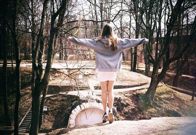 Rear view of woman standing in front of tree