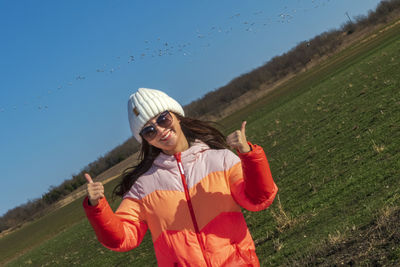 Portrait of smiling woman gesturing on field