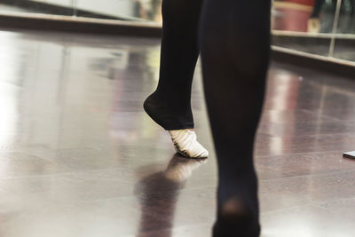 Low section of ballet dancer practicing on floor