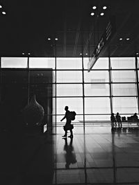 Silhouette man standing by window at airport
