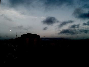 Buildings in city against cloudy sky