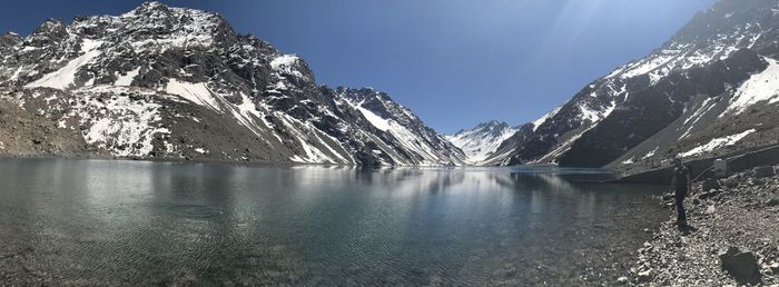 Scenic view of frozen lake by snowcapped mountains against sky