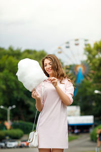 Smiling young woman holding cotton candy