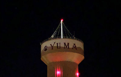 Low angle view of illuminated tower against sky at night