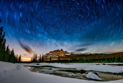 Scenic view of snowcapped landscape against sky at night