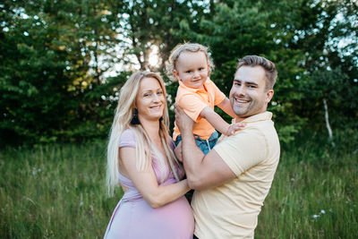 Portrait of happy family standing on field