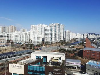 High angle view of buildings against clear blue sky