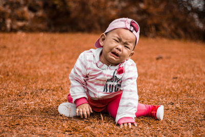 Close-up of baby girl crying on field