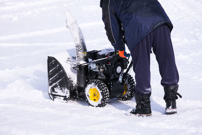 Low section of man skiing on snow covered field