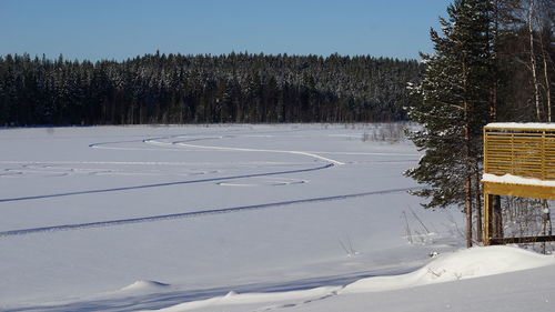 Snow covered landscape against clear sky