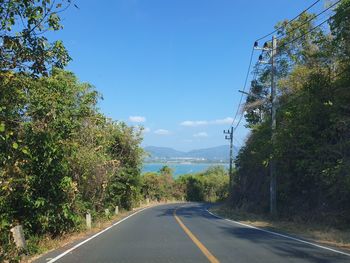 Road amidst trees against sky