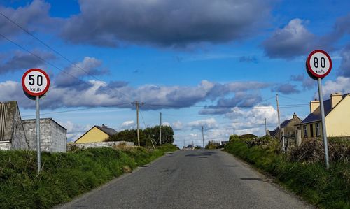 Road sign against sky in city