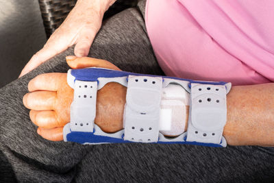Midsection of woman with belt on hand