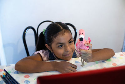 Portrait of cute girl with toy at home