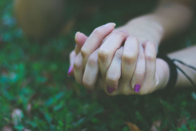 Cropped image of friends holding hands at park