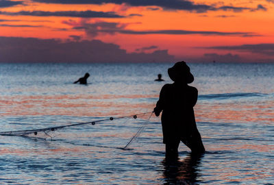 A fisherman is fishing at sunset on koh rong, cambodia