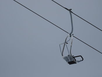 Low angle view of overhead cable car against sky