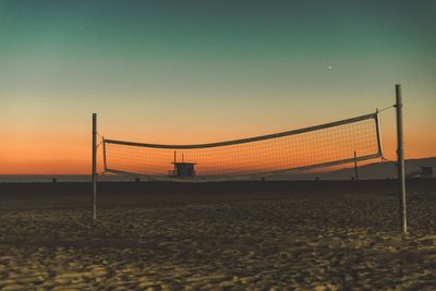 Scenic view of beach against clear sky during sunset