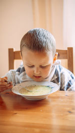 Close-up of cute boy eating food on table