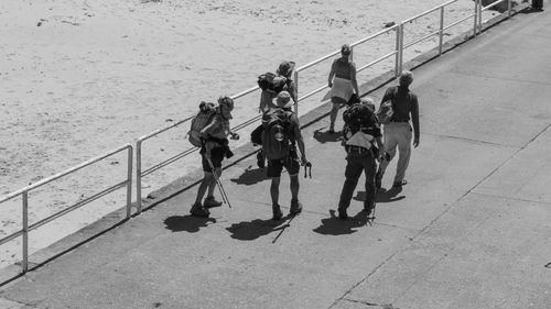 High angle view of people standing by railing in sea