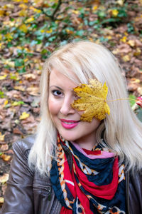 Portrait of smiling young woman with autumn leaves