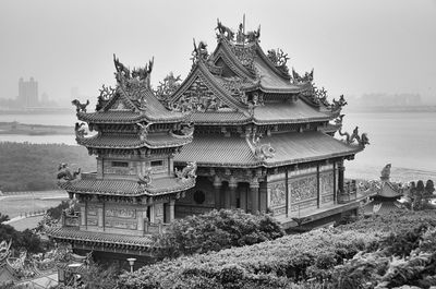 Guandu temple by river against sky