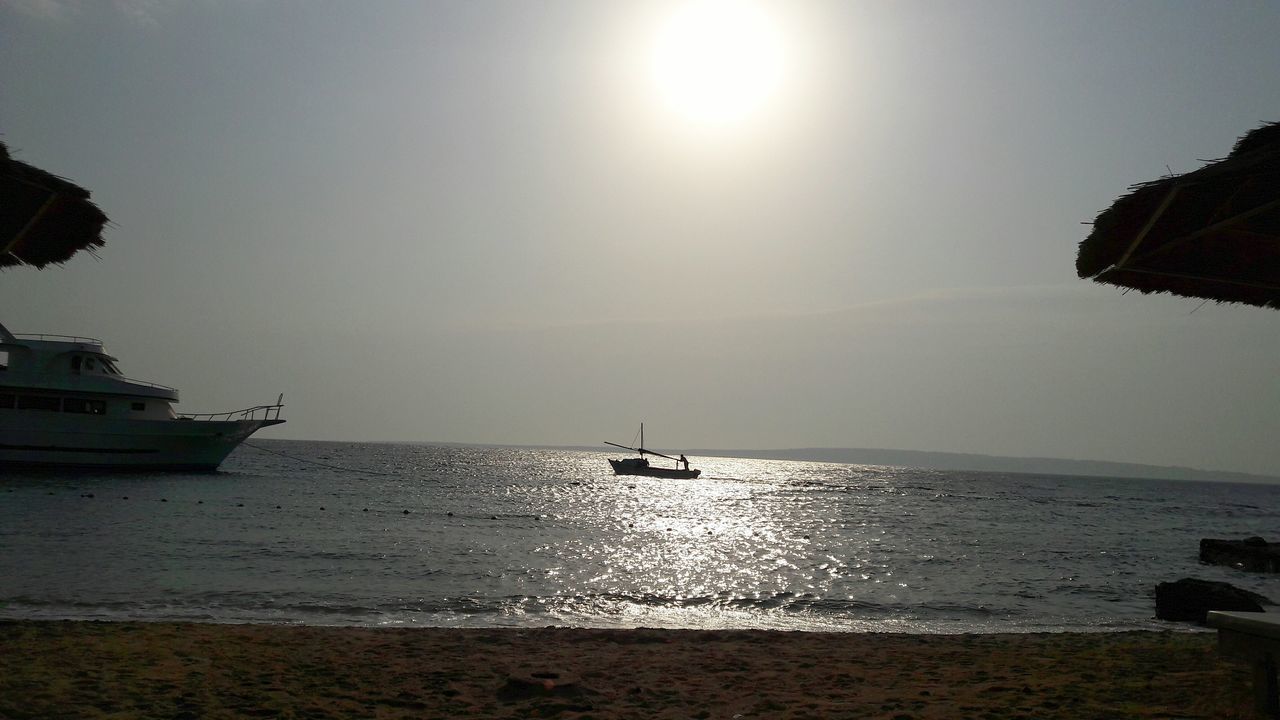 sea, water, sun, horizon over water, nature, beauty in nature, beach, scenics, nautical vessel, sunlight, tranquility, sky, tranquil scene, silhouette, outdoors, sunset, no people, clear sky, day