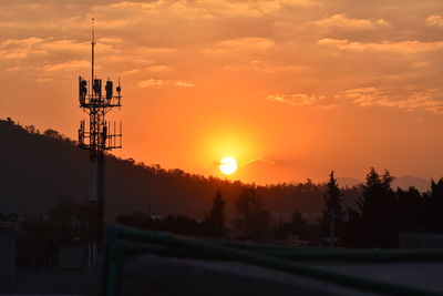 Electricity pylon against sky during sunset