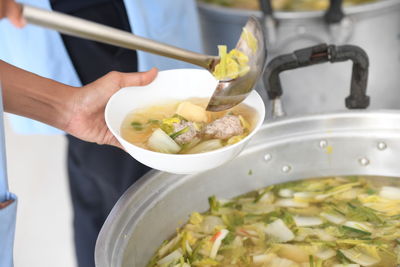 Midsection of person preparing food in kitchen