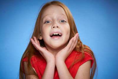 Close-up of young woman against blue background